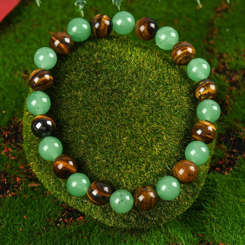 Alternating pale green and golden-brown round-bead bracelet on a moss background