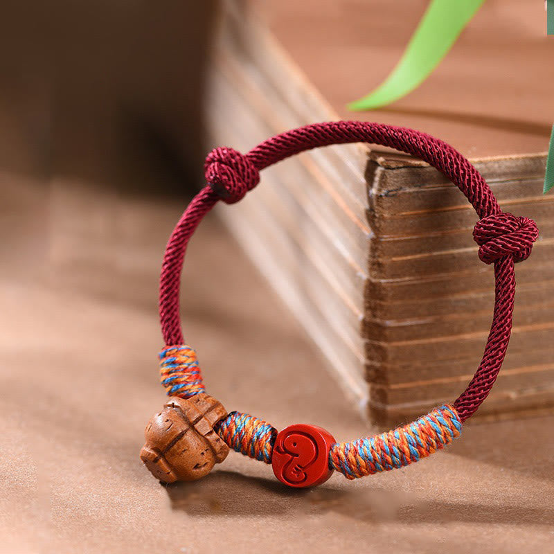 Bracelet porte-bonheur artisanal Foviel à cordon rouge, signe du zodiaque chinois, noyau de pêche et cinabre