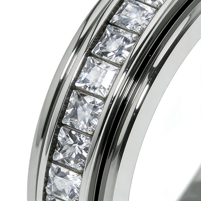 Close detail of clear square faceted stones, central channel and polished ring edges.