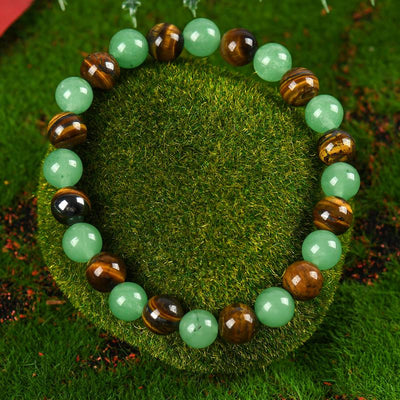 Alternating pale green and golden-brown round-bead bracelet on a moss background