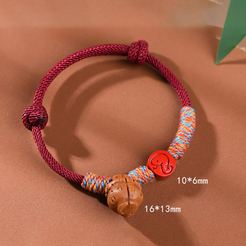 Bracelet porte-bonheur artisanal Foviel à cordon rouge, signe du zodiaque chinois, noyau de pêche et cinabre