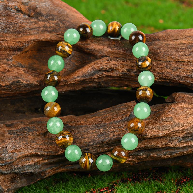 Green and golden-brown alternating bead bracelet resting on wood