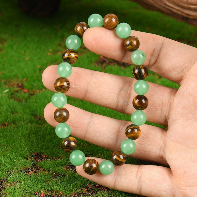 Close view of alternating green and golden-brown beads held in a hand