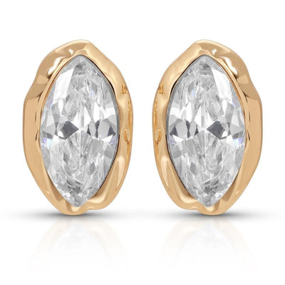 Pair of clear marquise faceted studs in organic gold-tone settings on white.
